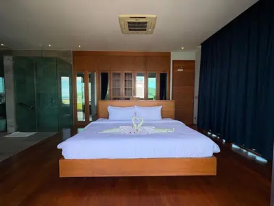 a bedroom with a large bed and a glass shower at Villa Sa in Ban Saiyuan (1)