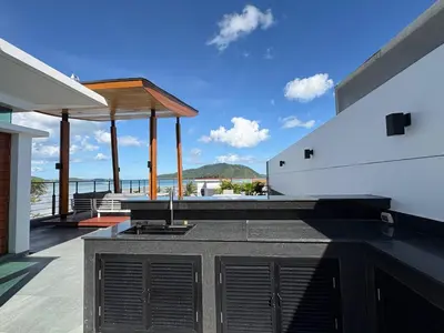 an outdoor kitchen with a view of the ocean at Villa Sa in Ban Saiyuan (1)
