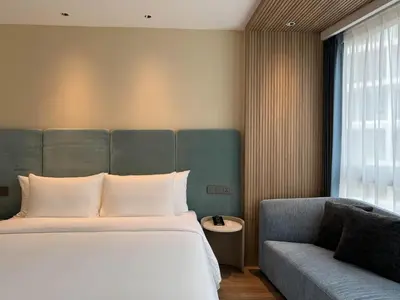 a bedroom with a bed and a couch at Laya Suites and Residences in Bang Tao Beach