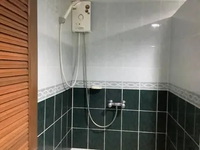 a shower with a hose in a green tiled bathroom at Freedom house in Karon Beach
