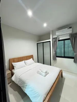 a bedroom with a bed with two towels on it at Lela Home in Phuket Town