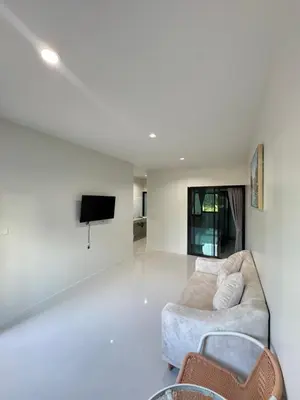 a living room with a couch and a tv at Lela Home in Phuket Town
