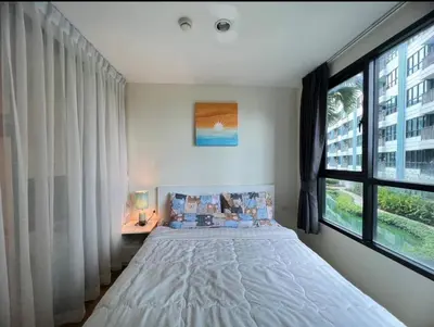 a bedroom with a bed and a large window at Centrio condo near central Phuket in Ban Rangeng