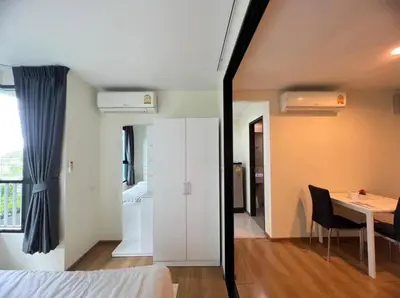 a bedroom with a white cabinet and a table in a room at Centrio condo near central Phuket in Ban Rangeng