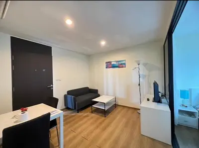 a living room with a couch and a table at Centrio condo near central Phuket in Ban Rangeng