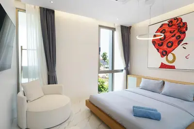 a white bedroom with a bed and a chair at Luxury Villa Residence near Laguna in Ban Pak Lak
