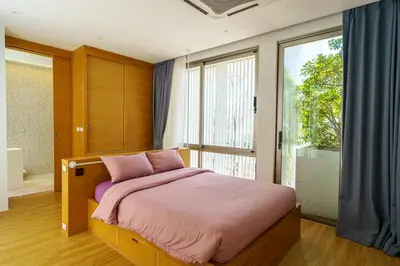 a bedroom with a bed with pink sheets and a window at Luxury Villa Residence near Laguna in Ban Pak Lak