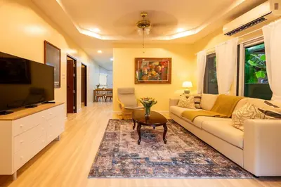 a living room with a couch and a tv at Kamala Beach House, 7-Min Walk to Beach in Kamala Beach