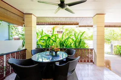 a patio with a table and chairs and a ceiling fan at Kamala Beach House, 7-Min Walk to Beach in Kamala Beach