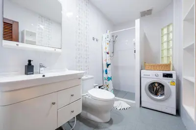 a white bathroom with a toilet and a washing machine at Kamala Beach House, 7-Min Walk to Beach in Kamala Beach