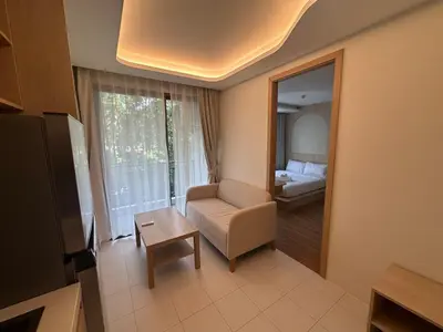 a room with a couch and a chair and a mirror at Kamala Apartments in Kamala Beach