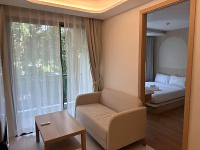 a living room with a couch and a bed and a mirror at Kamala Apartments in Kamala Beach
