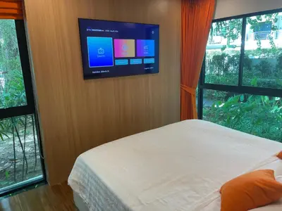a bedroom with a bed and a tv on a wall at Rawai Title 3 in Rawai Beach