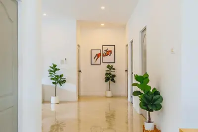 a hallway with two potted plants and white walls at Wink Garden 3 Bedrooms Bangtao Beach Phuket in Ban Thalat Choeng Thale