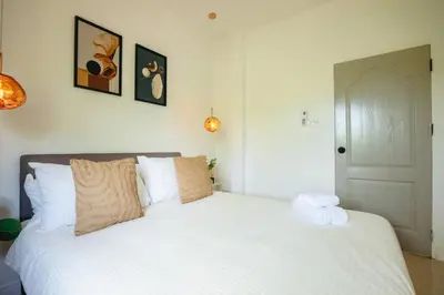 a bedroom with a large white bed with pillows at Wink Garden 3 Bedrooms Bangtao Beach Phuket in Ban Thalat Choeng Thale
