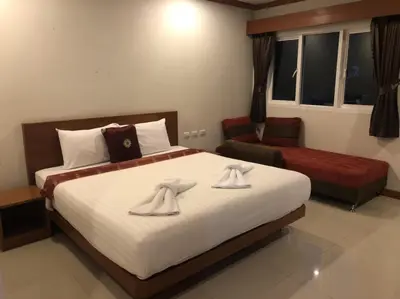 a bedroom with a large bed with towels on it at Chollada inn kamala in Kamala Beach
