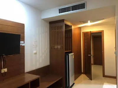 a room with a television and a door with a door at Chollada inn kamala in Kamala Beach