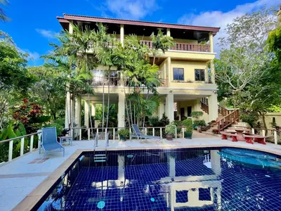 a house with a swimming pool in front of a house at Kata Sunset Bay Villa - 3BR Private Pool - Seaview in Kata Beach