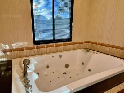 a bath tub in a bathroom with a window at Kata Sunset Bay Villa - 3BR Private Pool - Seaview in Kata Beach