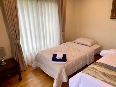 a bedroom with two beds and a hat on the bed at Kata Sunset Bay Villa - 3BR Private Pool - Seaview in Kata Beach