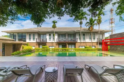 a house with a pool and chairs in front of it at Antiya Hotel Phuket in Phuket Town