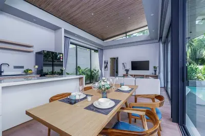 a dining room with a wooden table and chairs at Stylish 2BR Naiton Aileen Villa w Private Pool in Nai Thon Beach