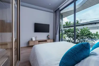 a bedroom with a large bed and a television at Stylish 2BR Naiton Aileen Villa w Private Pool in Nai Thon Beach