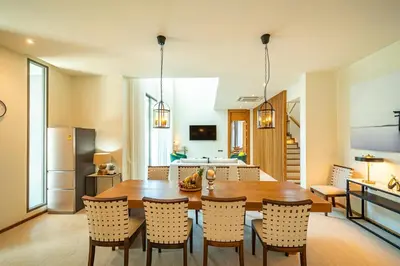 a kitchen and dining room with a wooden table and chairs at Teak 5 BR Pool Villa Bang Tao Airport Shuttle in Laguna Phuket