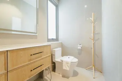 a bathroom with a toilet and a tree in it at Teak 5 BR Pool Villa Bang Tao Airport Shuttle in Laguna Phuket