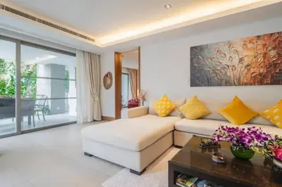 a living room with a couch and a table at Elegant Beachfront 3BR Condo at Pearl of Naithon in Nai Thon Beach