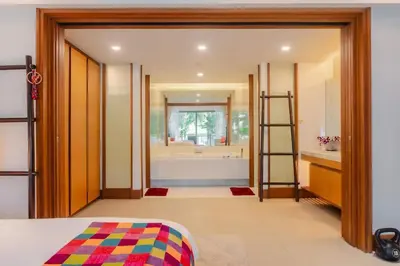 a bedroom with a bathroom with a tub and a bed at Elegant Beachfront 3BR Condo at Pearl of Naithon in Nai Thon Beach