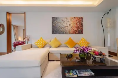 a living room with a white couch and a table at Elegant Beachfront 3BR Condo at Pearl of Naithon in Nai Thon Beach
