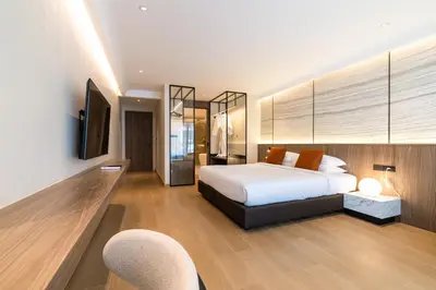 a bedroom with a bed and a tv and two chairs at P Villas Patong in Patong Beach