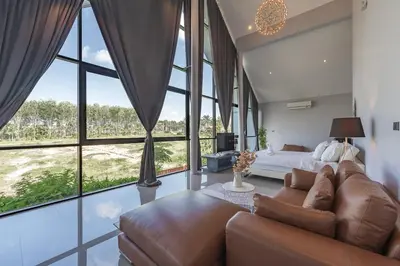 a living room with a couch and a bed and windows at V188 The Granary Loft Haven 3BR Pool Sanctuary in Bang Tao Beach