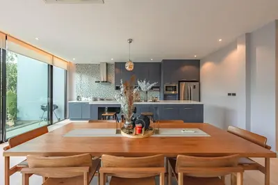 a kitchen with a large wooden table and chairs at V188 The Granary Loft Haven 3BR Pool Sanctuary in Bang Tao Beach