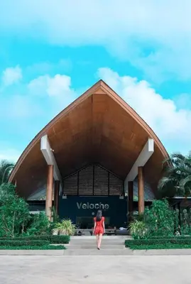 a woman in a red dress walking in front of a building at Breathtaking Sea & Mountain View Private Pool in Karon Beach
