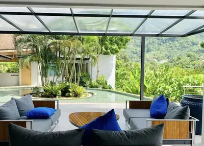 a living room with blue pillows and a pool at Breathtaking Sea & Mountain View Private Pool in Karon Beach
