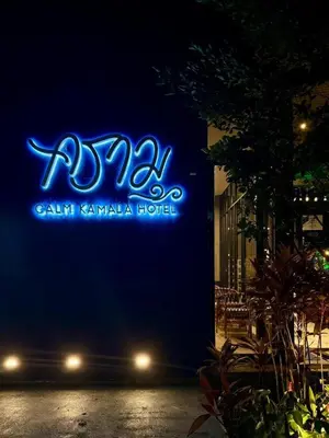 a blue neon sign on the side of a building at Calm Kamala Phuket in Kamala Beach