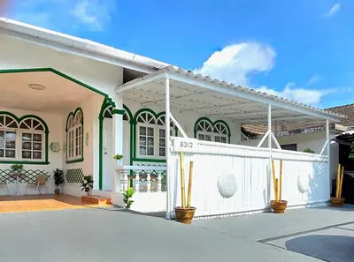 a white and green house with a white fence at Village Beach House I in Patong Beach