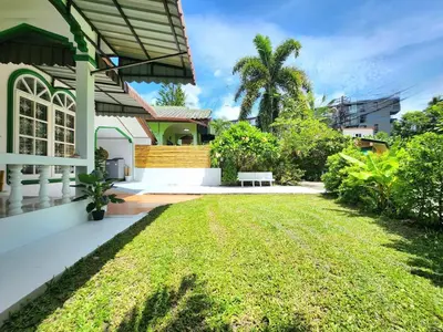 a backyard of a house with a grass yard at Village Beach House II in Patong Beach