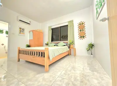 a bedroom with a bed and a window at Village Beach House II in Patong Beach