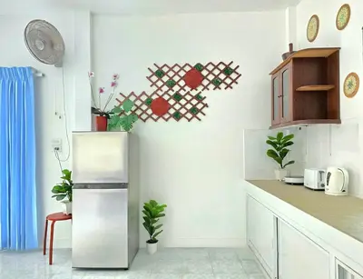 a kitchen with a refrigerator and some plants on the wall at Village Beach House III in Patong Beach