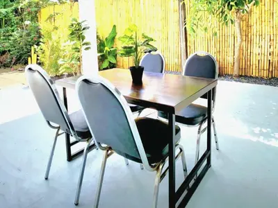 a wooden table with four chairs around it at Village Beach House III in Patong Beach