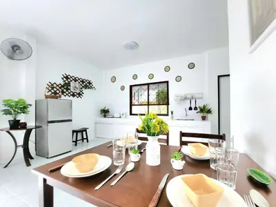 a kitchen and dining room with a wooden table at Village Beach House III in Patong Beach