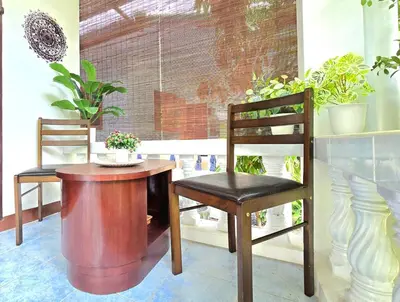 two chairs and a table and a chair with plants at Village Beach House III in Patong Beach