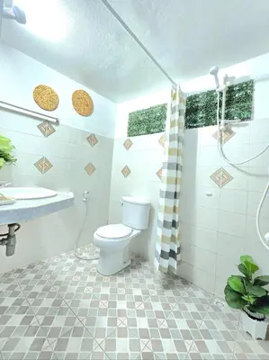 a bathroom with a toilet and a shower and a sink at Village Beach House IV in Patong Beach