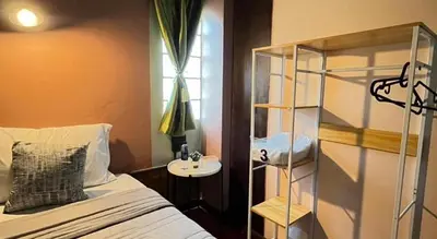 a bedroom with a bed and a sink and a shelf at Nora Bukit Hotel in Ban Sam Kong