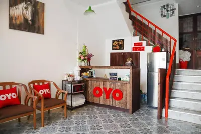 a living room with two chairs and a refrigerator at OYO 778 21 Poshtel in Phuket Town