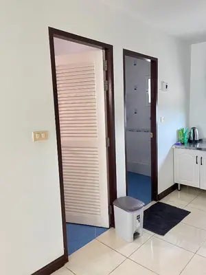 a bathroom with two doors and a trashcan in a room at TONY Central Stay in Phuket Town
