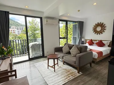 a bedroom with a bed and a couch and a window at \u8d85\u4fbf\u5229 199\u53f7\u82ad\u4e1c\u6d77\u6ee9\u7cbe\u88c5\u516c\u5bd3 5\u5206\u949f\u5230\u6d77\u6ee910\u5206\u949f\u5230\u9152\u5427\u8857 in Patong Beach